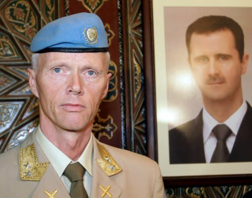 UN top observer Major General Robert Mood stands next to a portrait of Syrian President Bashar al-Assad upon his arrival in Damascus in April. Mood said on Wednesday he was "deeply disturbed" by a newly discovered massacre in Syria, as the opposition insisted Assad must step down if a peace plan is to be saved