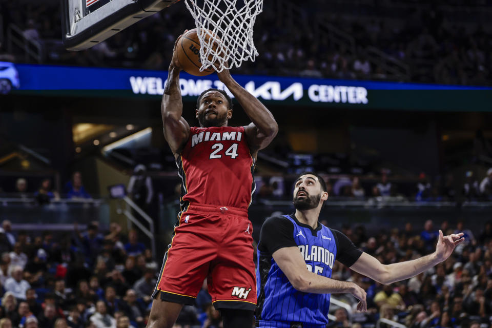 Miami Heat forward Haywood Highsmith (24) goes up for the shot as he is defended by Orlando Magic center Goga Bitadze, right, during the first half of an NBA basketball game, Wednesday, Dec. 20, 2023, in Orlando, Fla. (AP Photo/Kevin Kolczynski)