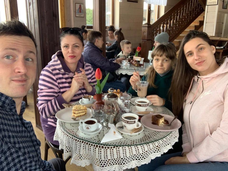 Ivan Oleskii, left, with his fiancée and her family in a café in April.