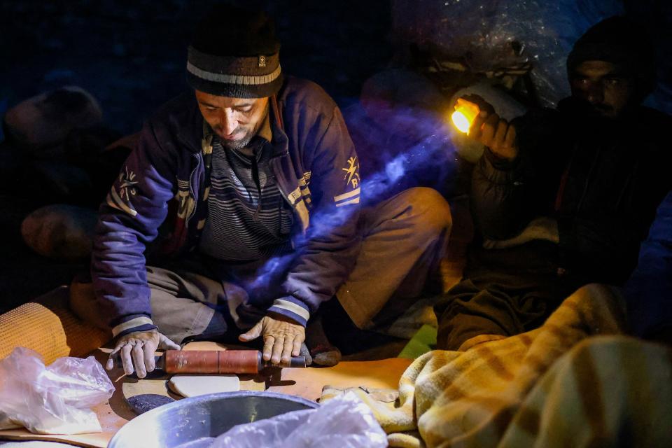 This picture taken on July 9, 2023, shows a Pakistani porter rolling dough at night on the trail between Askole and K2, world's second tallest mountain in the Karakoram range of GilgitBaltistan, Pakistan.