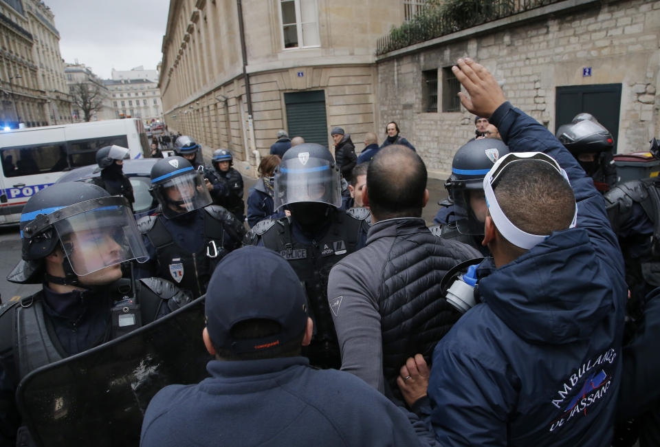 Ambulance workers face riot police officers outside the National Assembly in Paris, Monday, Dec. 3, 2018. Ambulance workers took to the streets and gathered close to the National Assembly in downtown Paris to complain about changes to working conditions as French Prime Minister Edouard Philippe is holding crisis talks with representatives of major political parties in the wake of violent anti-government protests that have rocked Paris. (AP Photo/Michel Euler)