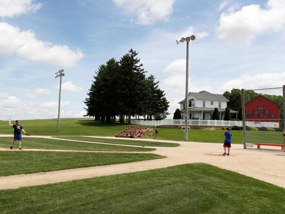 people playing baseball on the field of dreams movie site in iowa