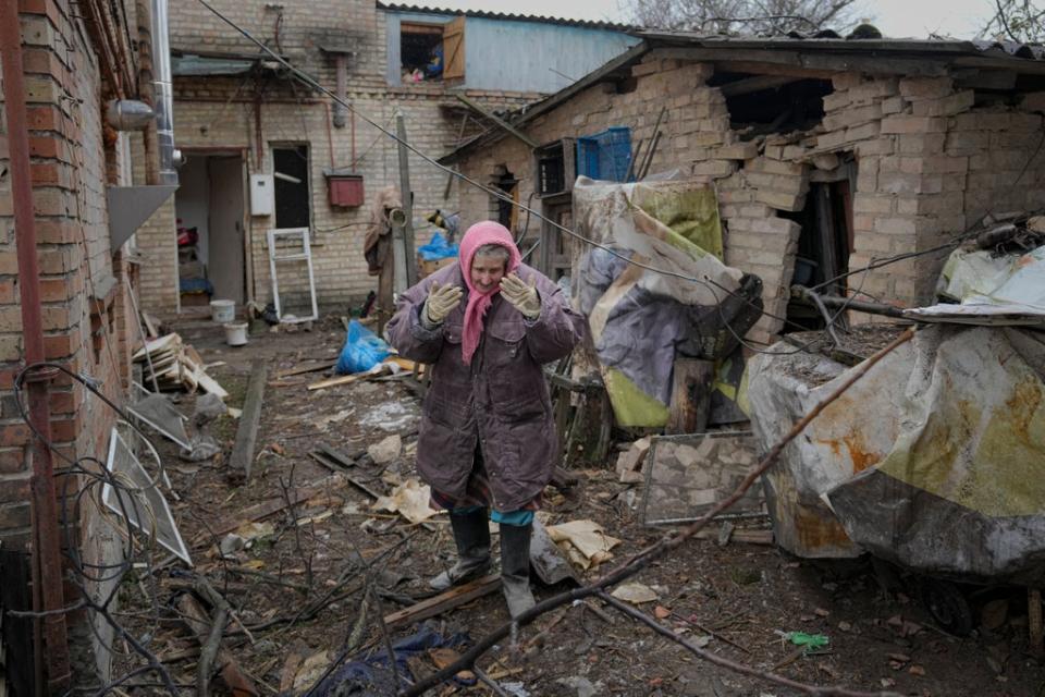 A lady is overwhelmed by emotion in the backyard of a house damaged by a Russian airstrike, according to locals, in Gorenka, outside the capital Kyiv, Ukraine (AP)