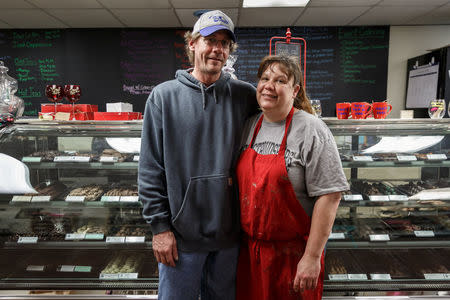 Travis and Kristy Vliet pose during a momentary break from dipping chocolate strawberries on Valentine's Day in Kristy's "5 Kidz Kandy" store in Waynesburg, Pennsylvania, U.S., February 14, 2018. Picture taken February 14, 2018. REUTERS/Maranie Staab