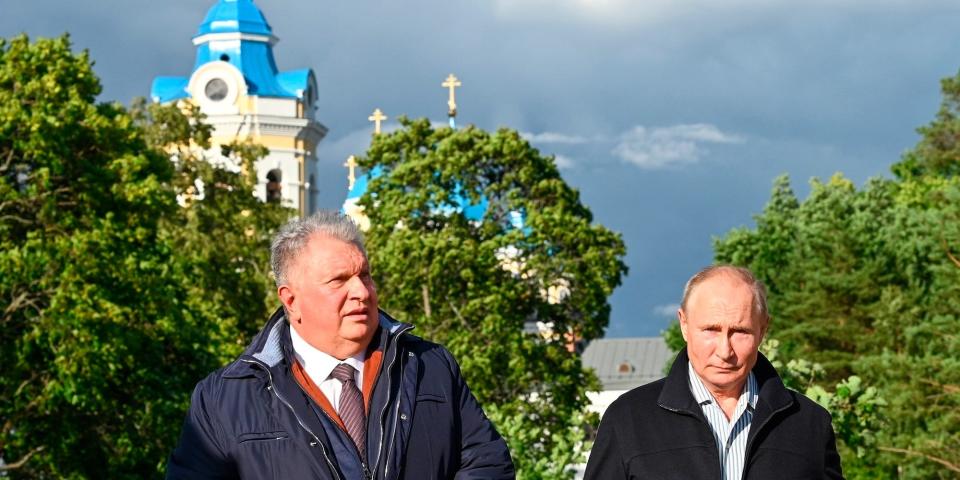 Russian President Vladimir Putin, right, and Russian CEO of Rosneft oil company Igor Sechin seen with the Konevsky Monastery on the Lake Ladoga behind them, Saturday, July 31, 2021.