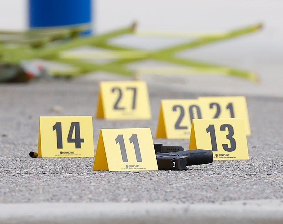 A gun lies on the ground surrounded by evidence markers after a shooting at the Brooklands Plaza Splash Pad in Rochester Hills, Mich., on June 15, 2024.