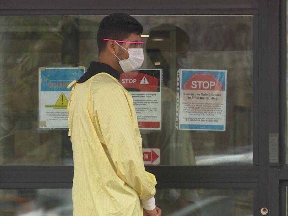 A worker is shown outside a long-term care facility in Winnipeg in an October 2020 photo. Shared Health estimates nearly one-quarter of roughly 42,000 health-care workers in the province had yet to disclose their vaccination status as of Friday. (Lyzaville Sale/CBC - image credit)