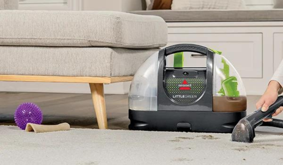 the bissell carpet cleaner being used to remove stains from an area rug