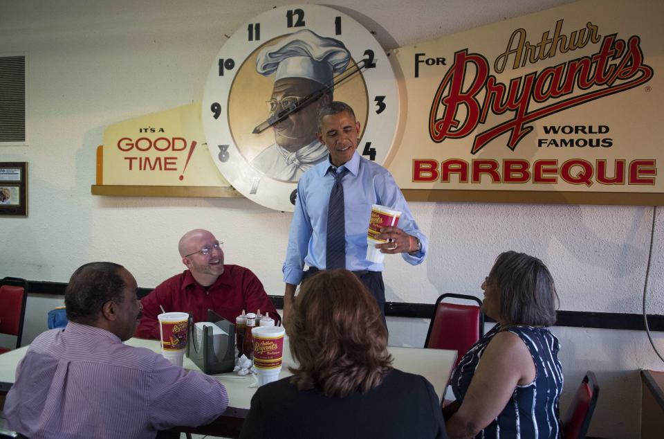 President Barack Obama (center) looks at a large soda at Arthur Bryant's Barbecue in Kansas City, Missouri, before having dinner with four local residents July 29, 2014. Pictured is Mark Turner (left), Victor Fugate (second from left), Valerie McCaw (second from right) and Becky Forrest (right).