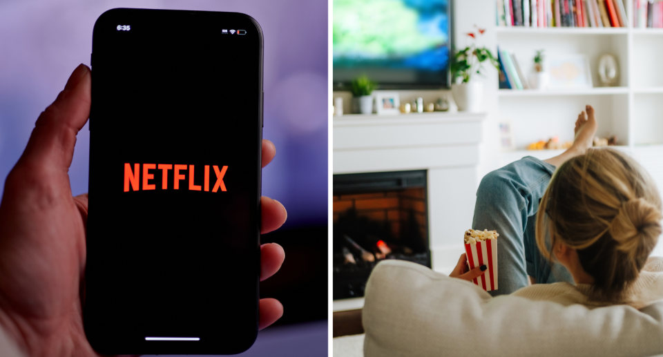 Person holding phone showing Netflix logo next to person watching TV at home