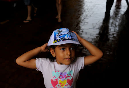A child puts on a cap with words reading "Welcome Pope Francis" at Carriage square, before the pope arrives to lead a holy mass on Sunday in Cartagena, Colombia September 9, 2017. REUTERS/Nacho Doce