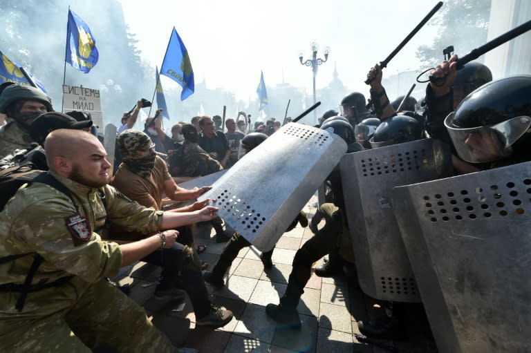 People try to pull shields away from officers as activists of radical Ukrainian parties, including the Ukrainian nationalist party Svoboda (Freedom), clash with police officers in front of the parliament in Kiev on August 31, 2015