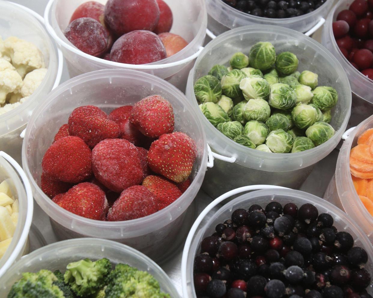 Assorted frozen fruits and vegetables in a plastic container