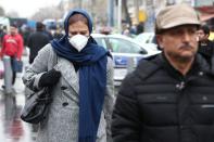 An Iranian woman wears protective mask to prevent contracting a coronavirus, as she walks at Grand Bazaar in Tehran