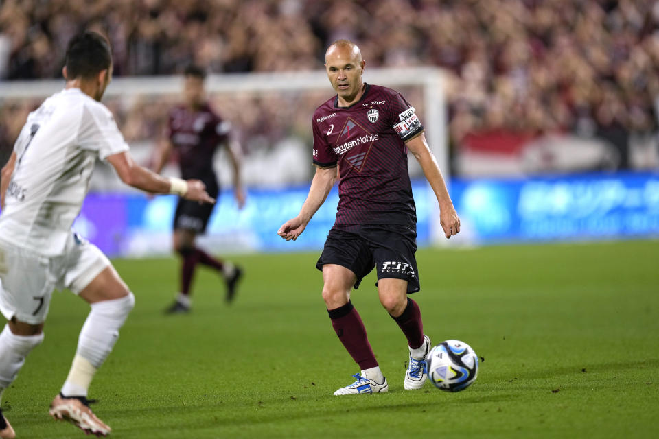 Vissel Kobe midfielder Andres Iniesta, right, passes the ball against Consadole Sapporo midfielder Lucas Fernandes during the first half of a friendly soccer match in Kobe, Japan, Saturday, July 1, 2023. The 39-year-old Spanish footballer plays his last match for the Japanese club Saturday. (AP Photo/Hiro Komae)