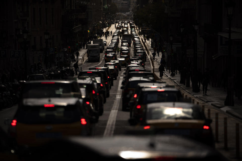 Taxi cabs move slowly blocking the traffic along one of the avenues in Barcelona downtown, Spain, Thursday, March 18, 2021. Hundreds of yellow-and-black cabs disrupted Barcelona's road traffic on Thursday to protest against the return of the ride-hailing giant Uber to the northeastern city after a 2-year hiatus. (AP Photo/Emilio Morenatti)