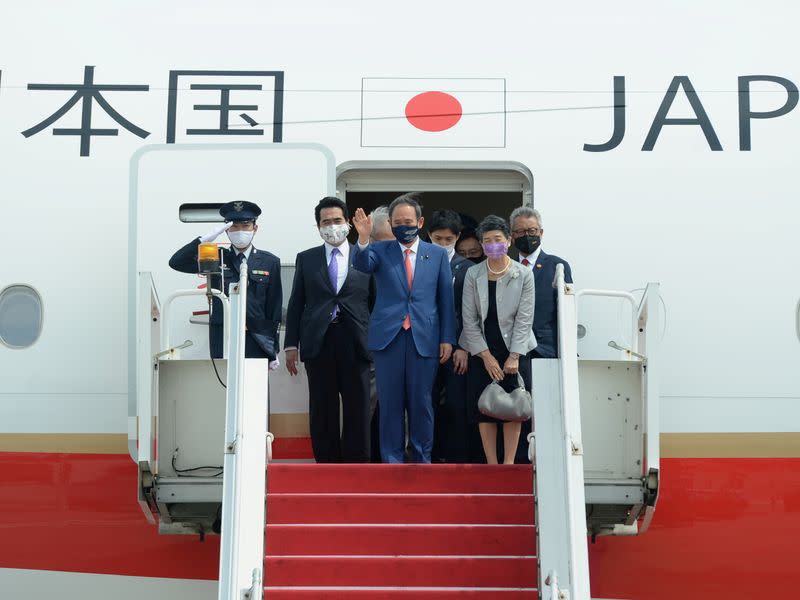 Japan's Prime Minister Yoshihide Suga waves as he arrives at Soekarno-Hatta International Airport during his visit, in Tangerang near Jakarta