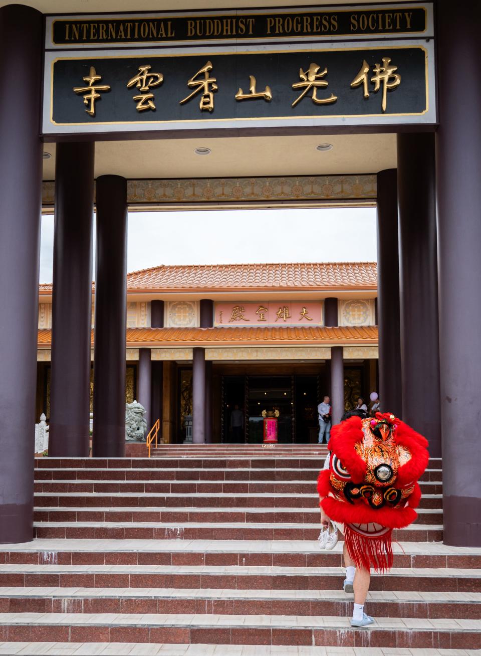 A member of the Heavenly Dragon Lion Dance Association carries a lion head into Fo Guang Shan Xiang Yun Temple ahead of practice in Austin, May 11, 2024.