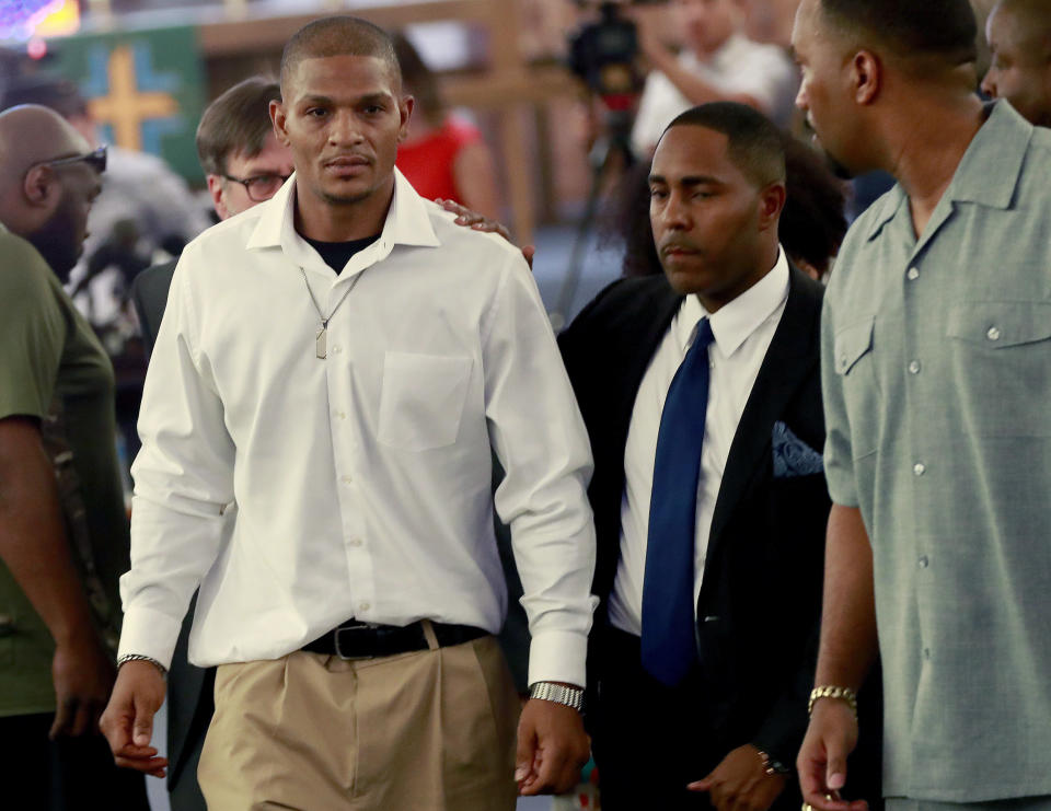 FILE - In this June 7, 2018, file photo, Robert Johnson, 35, left, leaves after his statement at New Beginnings Christian Church in Mesa, Ariz. Suburban Phoenix police officers shown on video beating an unarmed Johnson as he stood against a wall three months ago should not face criminal charges, outside police investigators said Monday, Aug. 27, 2018, about one of a series of recent incidents that drew questions about the agency's use of force. (AP Photo/Matt York, File)