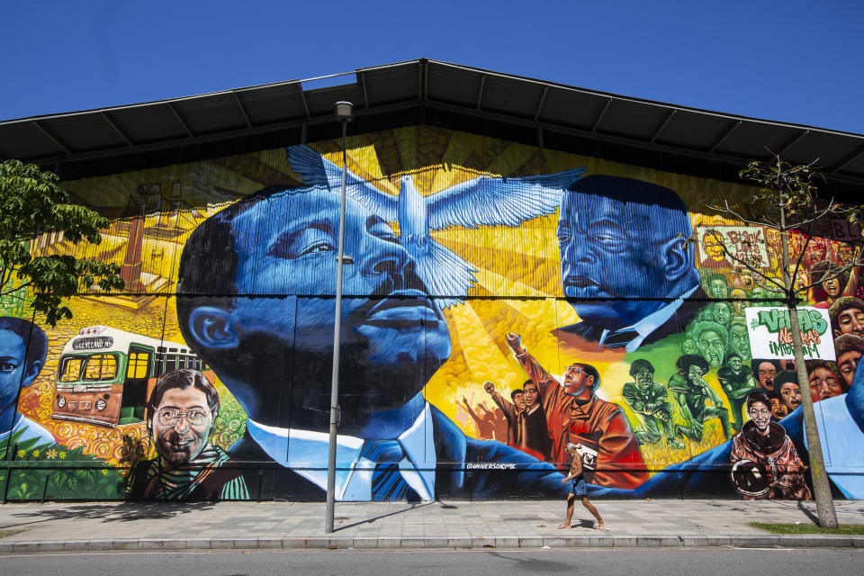 ARCHIVO - Un peatón pasa junto al mural Sonhos de Liberdade del artista Acme, que rinde homenaje a líderes por la lucha de la igualdad racial, en el distrito artístico de Porto en Río de Janeiro, Brasil, el 17 de noviembre de 2021. La discriminación permanece y los brasileños negros y birraciales tienen más posibilidades de ser pobres, estar en prisión y morir de forma violenta. (AP Foto/Bruna Prado, Archivo)