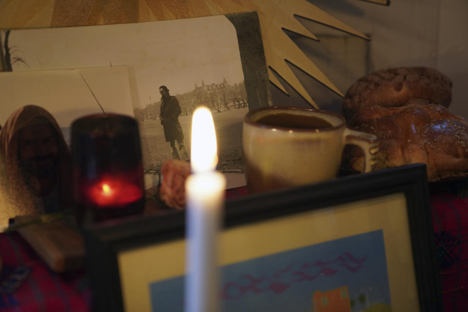 A photograph of Jose Diaz in his 20's sits next to coffee and pan de muerto, two of his favorite things to consume, in a Day of the Dead altar created by his son, Sebastian Diaz Aguirre in the Brooklyn borough of New York, Wednesday, Oct. 28, 2020. "I realized this year in a very special way how important my Mexican roots and this tradition was to me because it has been so comforting," said Diaz Aguirre, who set up his first ofrenda, or altar, since moving to the U.S. eight years ago. (AP Photo/Emily Leshner)