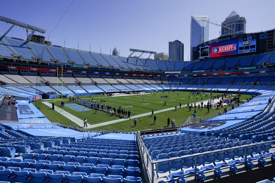 Members of the Carolina Panthers stand during a special presentation in an empty stadium before an NFL football game against the Las Vegas Raiders Sunday, Sept. 13, 2020, in Charlotte, N.C. (AP Photo/Chris Carlson)