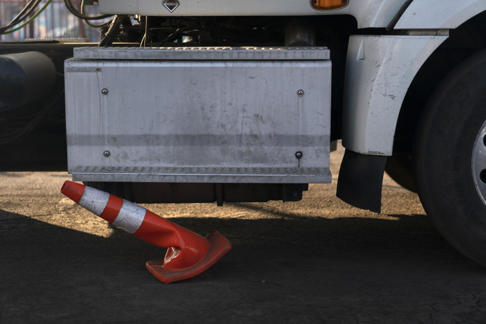 A traffic cone is stuck underneath a practice truck driven by a student driver at California Truck Driving Academy in Inglewood, Calif., Wednesday, Nov. 17, 2021. (AP Photo/Jae C. Hong)