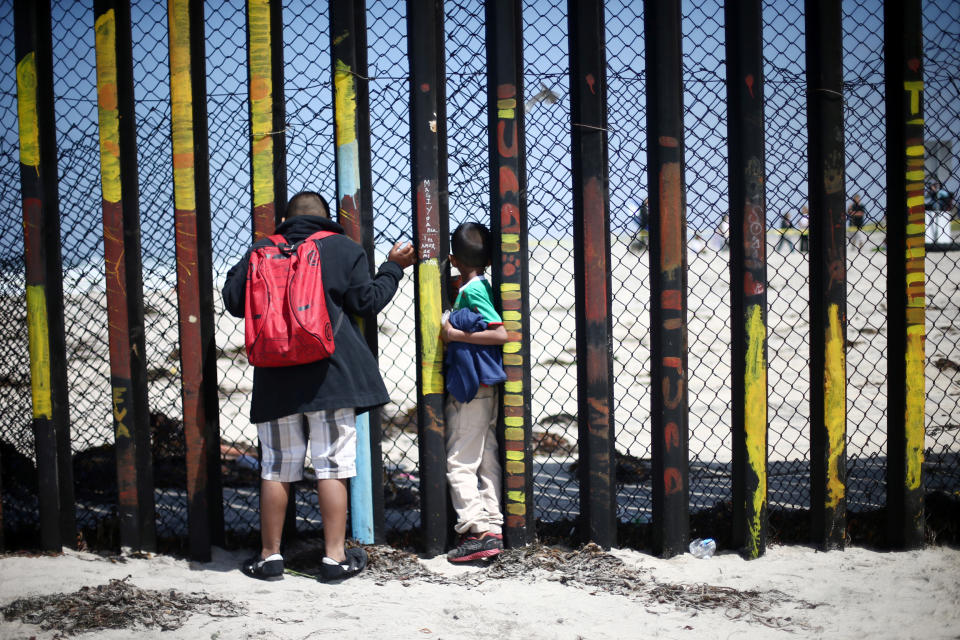 <p>Members of a caravan of migrants from Central America look through the border fence between Mexico and the U.S., prior to preparations for an asylum request in the U.S., in Tijuana, Mexico April 29, 2018. (Photo: Edgard Garrido/Reuters) </p>