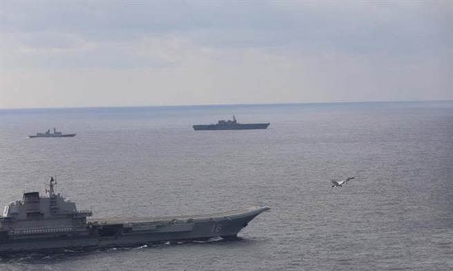 遼寧艦（前）連日在日本附近的太平洋上起降艦載機，日方派護衛艦出雲艦（後）監控。（圖／新華社）