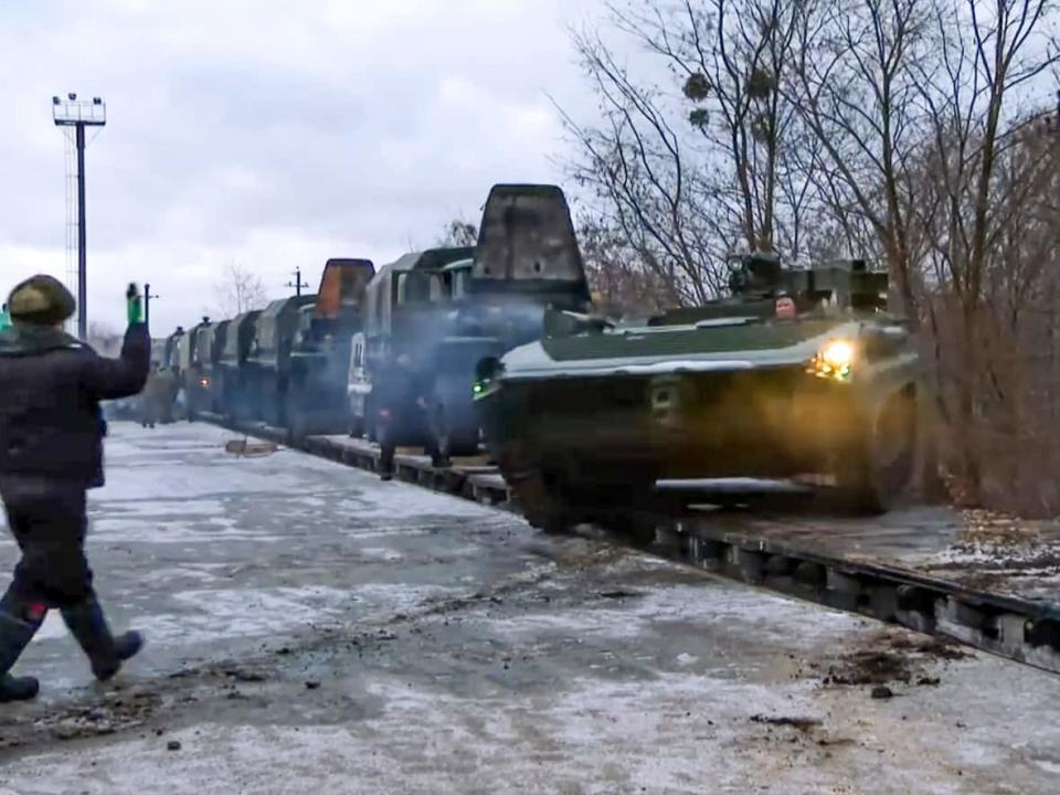 In this photo taken from video provided by the Russian Defence Ministry Press Service, a Russian armoured vehicle drives off a railway platform after arrival in Belarus, Wednesday, Jan. 19, 2022. (Russian Defense Ministry Press Service via AP - image credit)