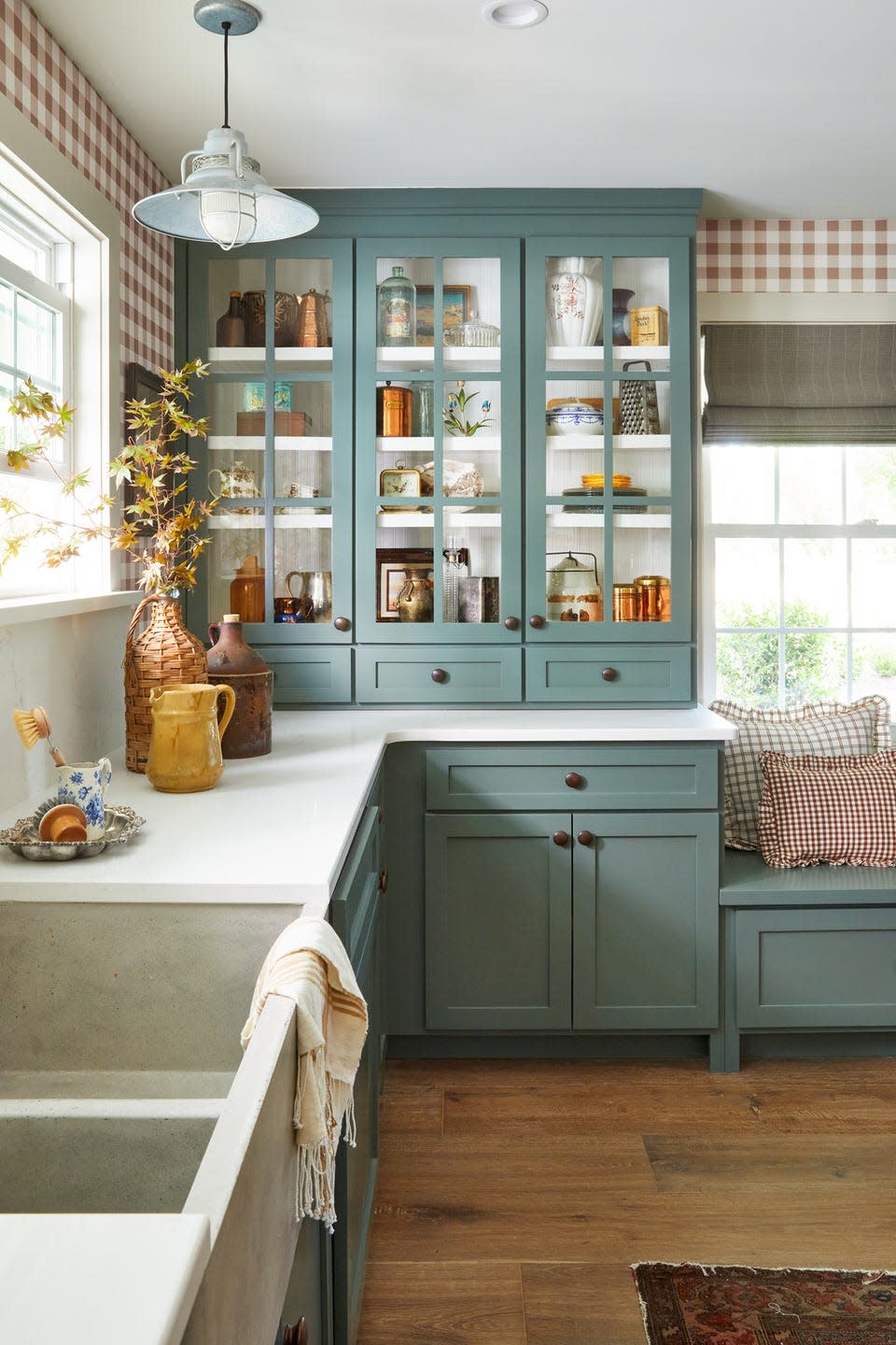 farmhouse kitchen with soft green painted kitchen cabinets showcasing a collection of antique dishware and kitchen decor