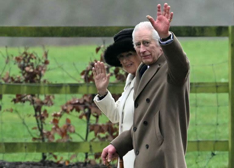 El rey Carlos III de Gran Bretaña y la reina Camila de Gran Bretaña saludan cuando salen después de asistir a un servicio en la Iglesia de Santa María Magdalena en Sandringham en el este de Inglaterra el 11 de febrero
 (JUSTIN TALLIS / AFP)