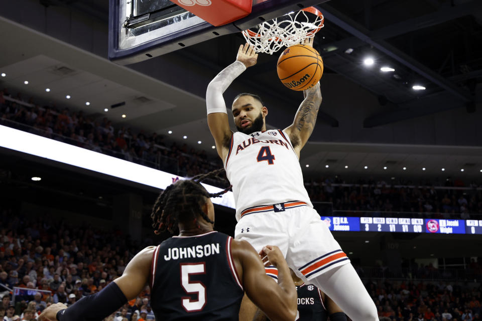 Auburn forward Johni Broome (4) slam dunks the ball over South Carolina guard Meechie Johnson (5) during the second half of an NCAA college basketball game Wednesday, Feb. 14, 2024, in Auburn, Ala. (AP Photo/Butch Dill)