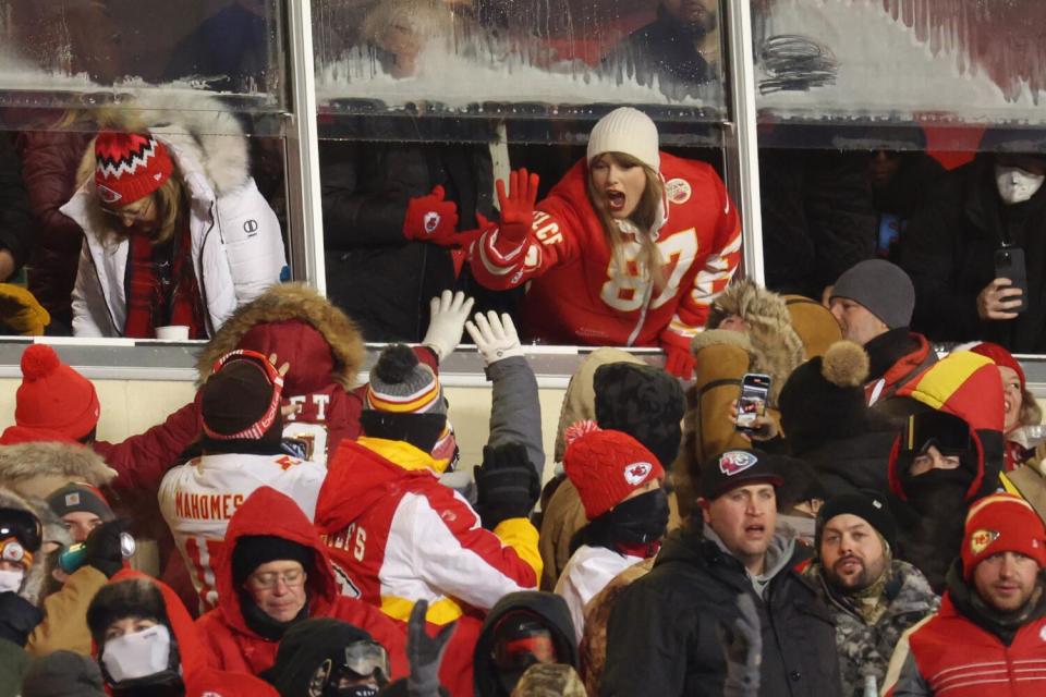 Taylor Swift celebrates with fans during the AFC Wild Card Playoffs against the Dolphins.