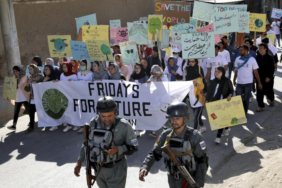 Young people attend a Climate Strike rally, as Afghan security forces guard them in Kabul, Afghanistan, Friday, Sept. 20, 2019. In the Afghan capitall, where people are dying every day in horrific bomb attacks, a young generation, worried that if war doesn't kill them climate change will, took part in the global climate strike. (AP Photo/Ebrahim Noroozi)