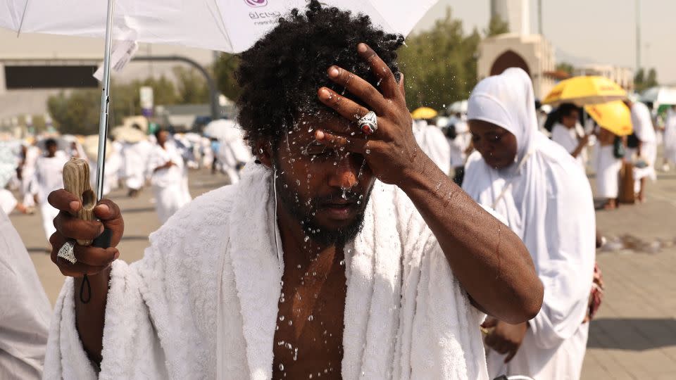A Muslim pilgrim splashes water on his head to cool off at the base of Saudi Arabia's Mount Arafat during the Hajj pilgrimage on June 15, 2024. - Fadel Senna/AFP/Getty Images