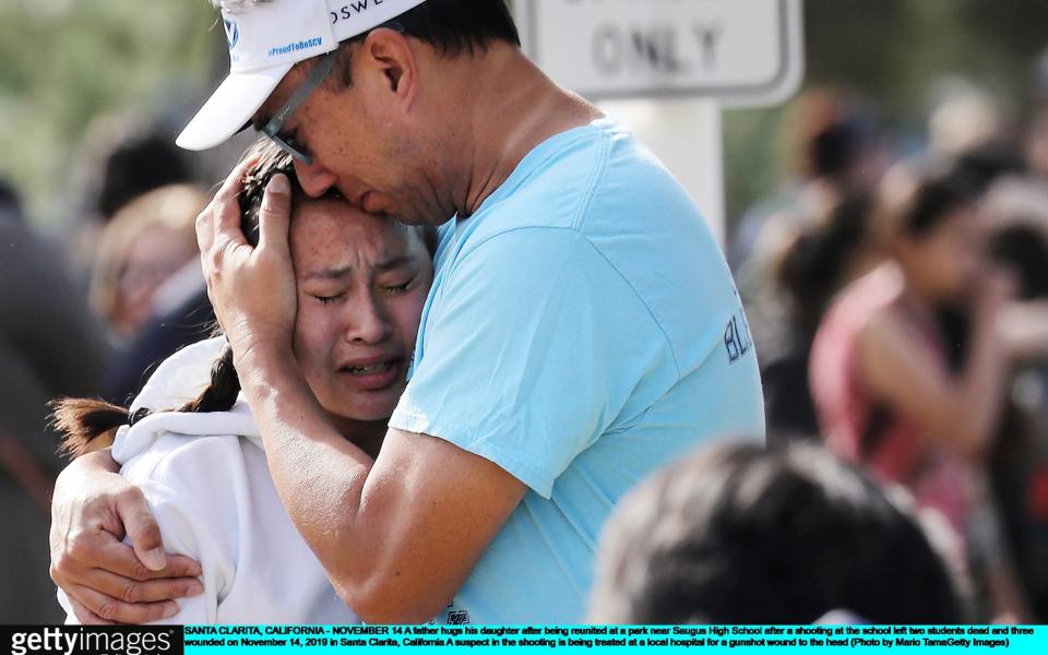 A father hugs his daughter after being reunited at a park near Saugus High School after a shooting at the school left two students dead and three wounded - Getty Images North America