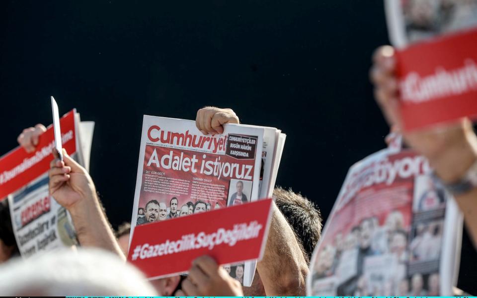 Protesters hold up copies of the days Cumhuriyet newspaper outside the central Istanbul court - Credit: Photo by Burak Kara/Getty Images