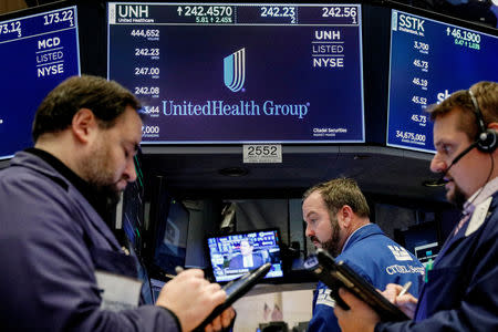 FILE PHOTO: Traders work at the post where UnitedHealth Group is traded on the floor of the New York Stock Exchange (NYSE) in New York, U.S., January 31, 2018. REUTERS/Brendan McDermid/File Photo