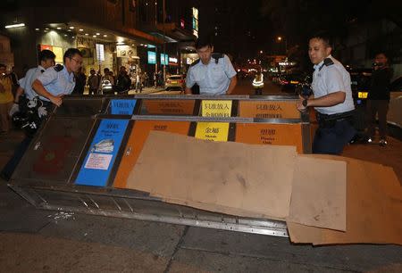 Policemen remove a litter bin after protesters used it as a barricade to block a side street at Mongkok shopping district in Hong Kong early November 29, 2014. REUTERS/Bobby Yip