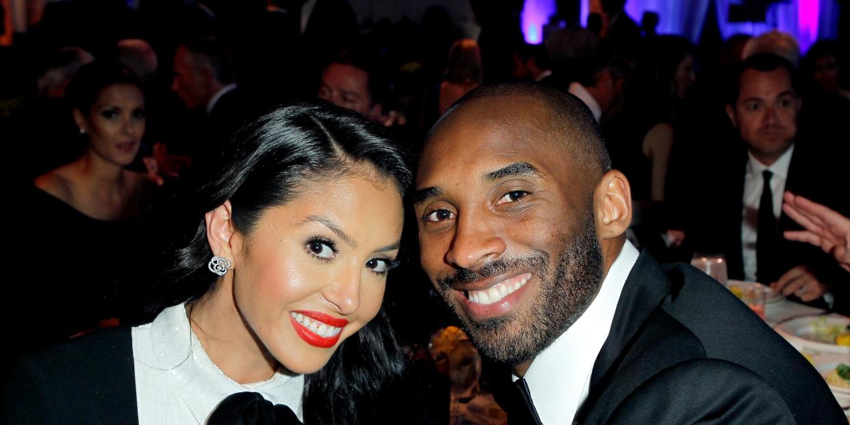 Vanessa Bryant (left) and Kobe Bryant (right) touching heads to pose for a photo in black and white attire