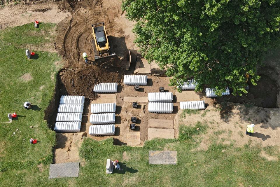 FILE - In this aerial photo, a mass grave is re-filled with dirt after a small ceremony at Oaklawn Cemetery, July 30, 2021, in Tulsa, Okla. The mass grave was discovered while searching for victims of the Tulsa Race Massacre. A forensic anthropologist believes investigators are a step closer to identifying victims of the 1921 Tulsa Race Massacre with the discovery of 19 surnames possibly connected to remains excavated from the Tulsa cemetery. (Mike Simons/Tulsa World via AP, File)/Tulsa World via AP)