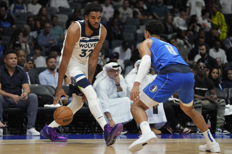 Josh Green of the Dallas Mavericks guards Karl-Anthony Towns of Minnesota Timberwolves during a preseason NBA game between Dallas Mavericks and Milwaukee Bucks Abu Dhabi, United Arab Emirates, Thursday, Oct. 6, 2023. (AP Photo/Kamran Jebreili)