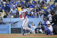 Arizona Diamondbacks' Christian Walker, left, hits a solo home run as Los Angeles Dodgers catcher Austin Barnes, center, and home plate umpire John Tumpane watch during the second inning of a baseball game Saturday, April 1, 2023, in Los Angeles. (AP Photo/Mark J. Terrill)