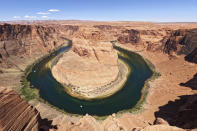 FILE - The Colorado River flows at Horseshoe Bend in the Glen Canyon National Recreation Area on June 8, 2022, in Page, Ariz. Las Vegas and Phoenix may be forced to ration water or restrict growth. Farmers may confront painful decisions about which crops to stop planting. Those are a few of the dire consequences that could result if states, cities and farms cannot agree on how to cut the amount of water they draw from the Colorado River. (AP Photo/Brittany Peterson, File)