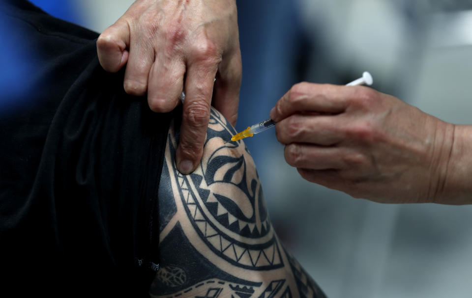 A tattooed person gets Pfizer vaccine at the National vaccination center in Prague, Czech Republic, Friday, April 9, 2021. On Friday the center, that is the biggest in the country, held its final trials before being able to vaccinate up to 10 000 people a day. (AP Photo/Petr David Josek)