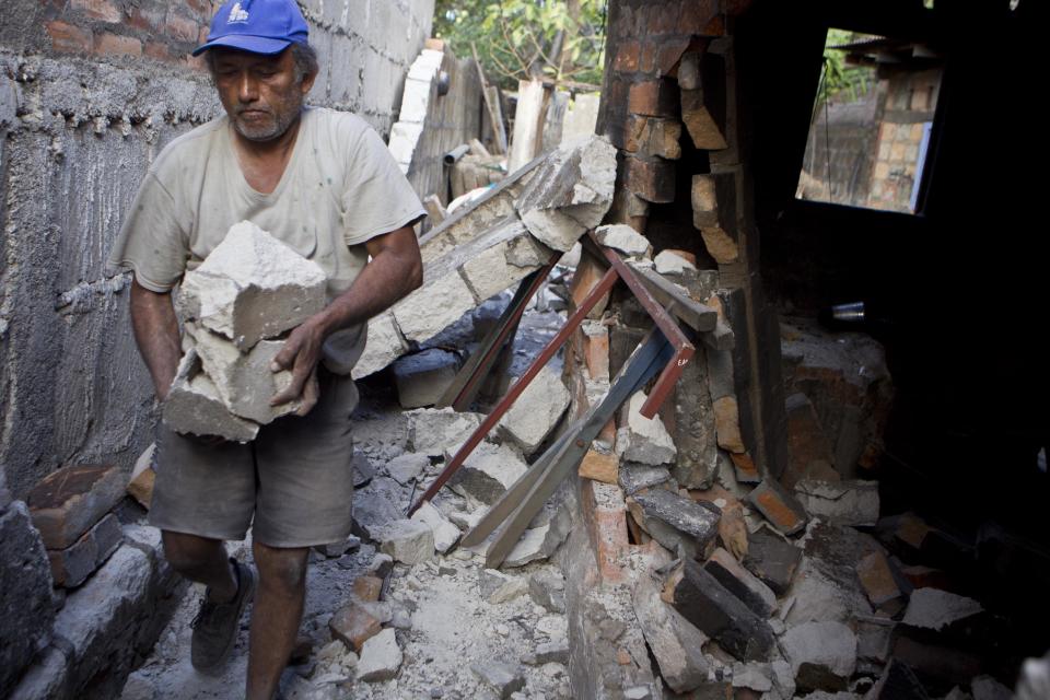 Un hombre retira escombros de su vivienda dañada por el fuerte sismo que azotó la localidad de Nagarote, en el oeste de Nicaragua, el jueves 10 de abril de 2014. El temblor de magnitud 6,1 dañó decenas de viviendas y dejó un muerto y más de 200 heridos. El presidente Daniel Ortega decretó el alerta roja en todo el país tras las continuas réplicas que siguieron al sismo. (AP Foto/Esteban Félix)