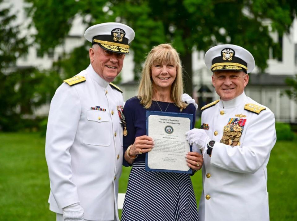 Marilyn Scott, wife of RADM Brent Scott, is presented with a certificate of Appreciation from Mike Gilday, Chief of Navy Operations during a change of office and retirement ceremony onboard Washington Navy Yard.