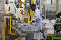 In this May 10, 2011 photo an autoworker assembles a transmission at the General Motors Transmission Plant in Toledo, Ohio. Defying a wave of layoffs that has sent the U.S. job market into its worst catastrophe on record, at least one major industry is making a comeback: Tens of thousands of auto workers are returning to factories that have been shuttered since mid-March due to fears of spreading the coronavirus. (AP Photo/Rick Osentoski)