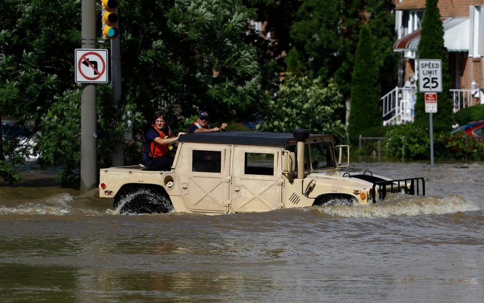 Philadelphia firefighters drive through a flooded neighbourhood on Tuesday - AP Photo/Matt Slocum